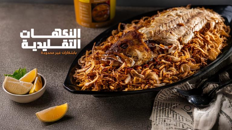 Whole baked fish served on a platter of rice and crispy onions, a traditional Gulf dish.