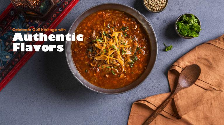 A bowl of traditional Gulf lentil soup with fresh herbs