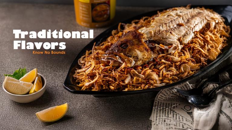 Whole baked fish served on a platter of rice and crispy onions, a traditional Gulf dish.